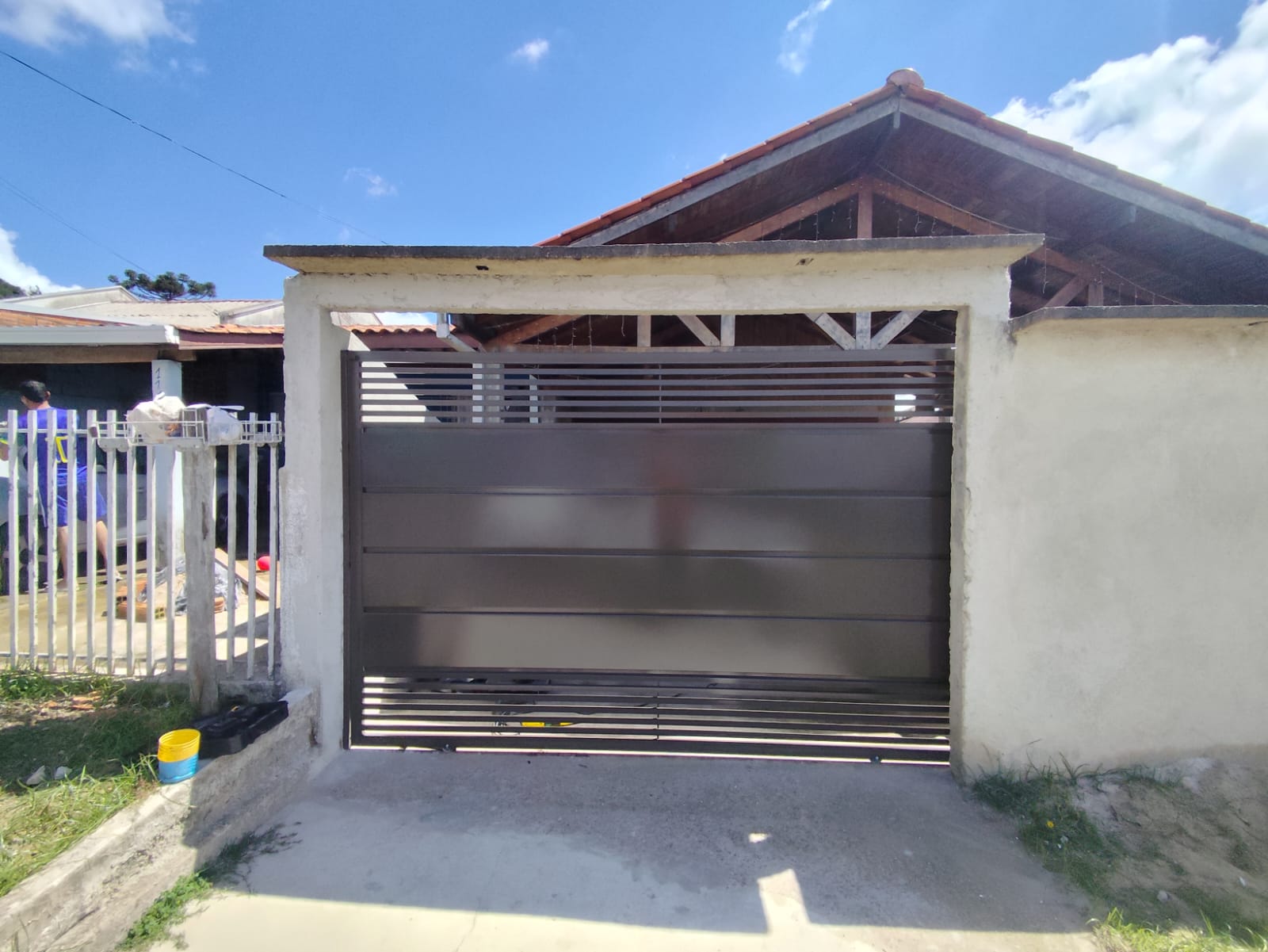 Portão de correr metálico com ripas horizontais revestido com acabamento Marrom 7533