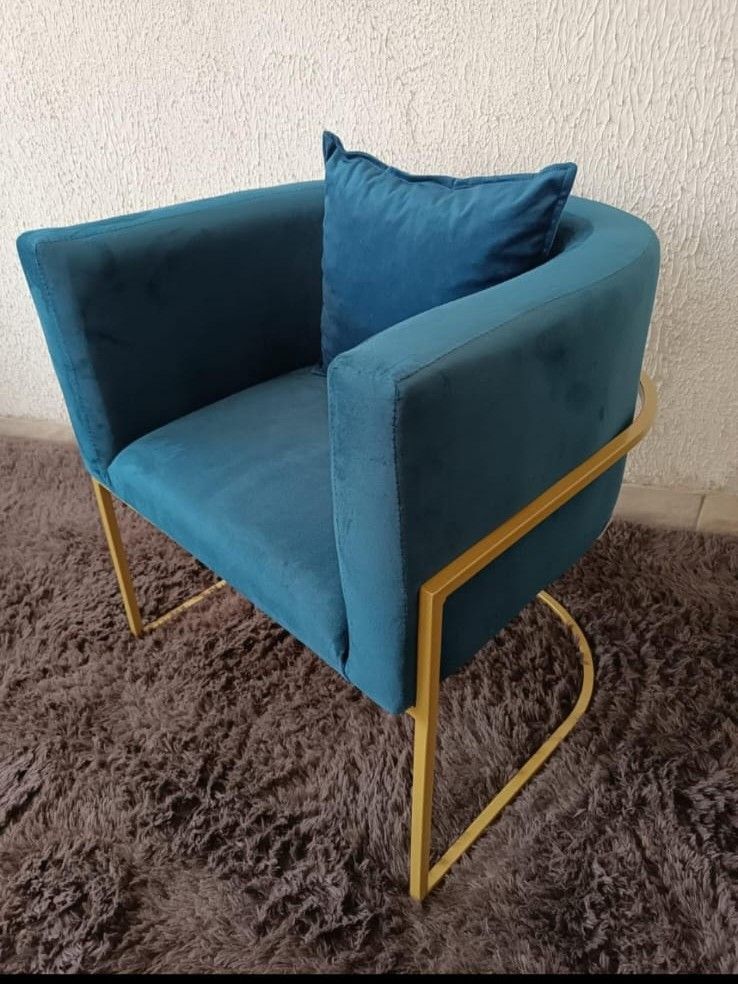 Poltrona de design com estrutura metálica tubular revestida em tinta eletrostática a pó Dourado e estofado em veludo azul
